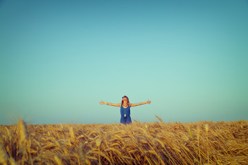 Girl relaxing in a wheat-field.