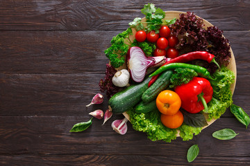 Dish of fresh vegetables on wooden background with copy space