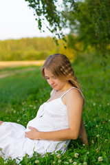 Fototapeta na wymiar portrait of a pregnant woman sitting on the grass