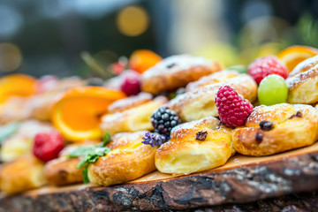 Catering buffet food outdoor. Cakes colorful fresh fruits berries oranges grapes and herb...