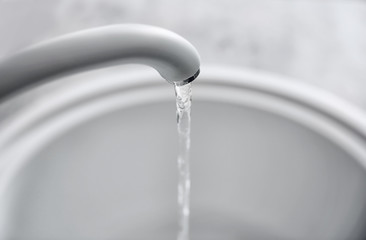 Water flowing from tap into sink in kitchen