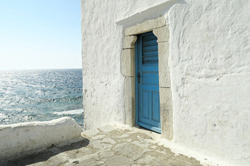 Mykonos, Greece – A blue door on a whitewashed wall. The entrance to one of the five churches that form The Church of Panagia Paraportiani. © bestravelvideo