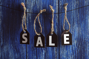 Sale labels hanging on wooden background