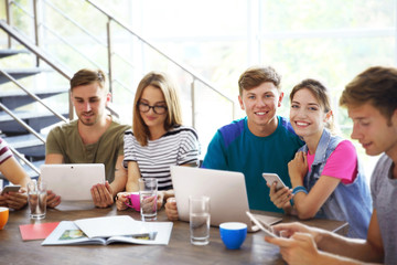 Young people with gadgets hanging out together