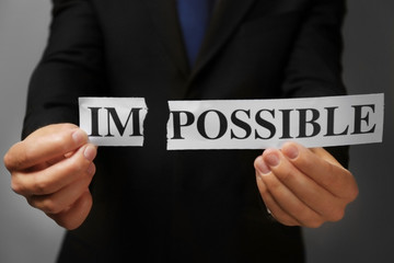 Businessman tearing paper with impossible word