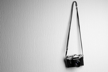 Vintage camera hanging on white textured background - Powered by Adobe