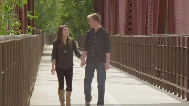 Young couple walking along a bridge