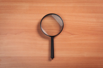 magnifying glass on the wooden background