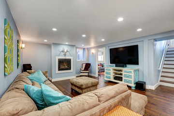 Pastel blue walls in basement living room interior. - obrazy, fototapety, plakaty