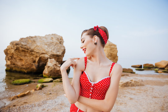 Young beautiful pin up girl in red swimsuit posing
