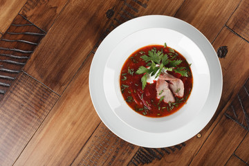 Borscht (borsch) - russian and ukrainian traditional soup in a white plate. wooden background