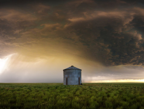 Supercell storm cloud and rain over a metal grain silo on the Great Plains, Colorado, Denver, USA
