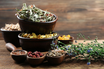 Natural flower and herb selection in  bowls on wooden background
