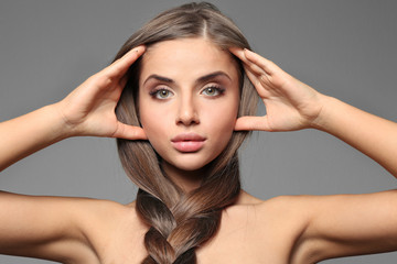 Fototapeta premium Young woman with healthy hair on color background