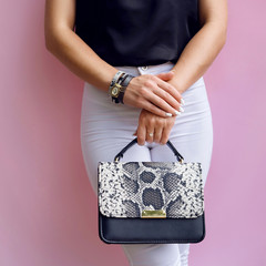 Trendy girl with fashion snake leather clutch and bracelet accessory