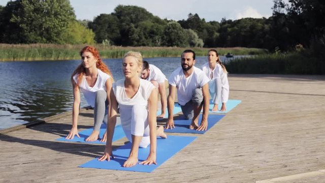 group of people making yoga exercises outdoors