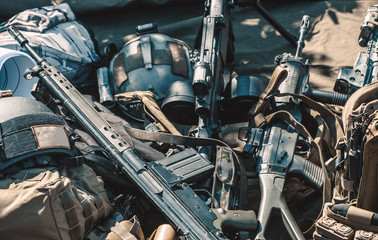 automatic machine machine gun helmet body armor piled in a heap lie on the ground.