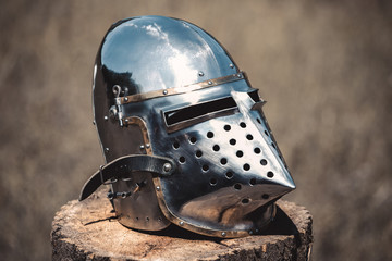 Fototapeta premium Knight, a brilliant helmet standing on a wooden stump. Close-up.