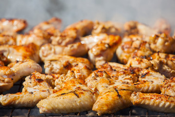 Marinated fried with a crispy golden crust fried chicken wings on the grill.