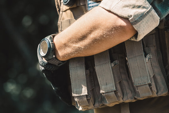 Male soldier wearing a bulletproof vest and a shirt with short sleeves. On hand watches. - Powered by Adobe