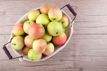 Fresh organic apples in basket on wooden table. Harvesting fruit