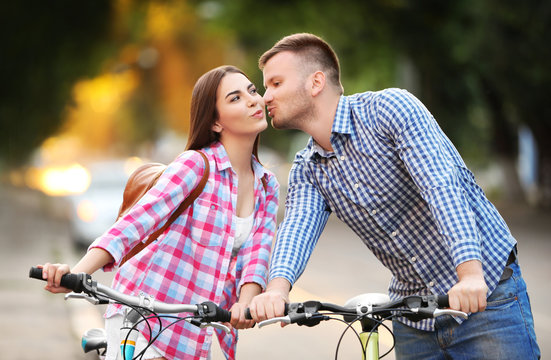 Young lovely couple riding bicycles on street