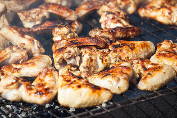 Marinated fried with a crispy golden crust fried chicken wings on the grill.