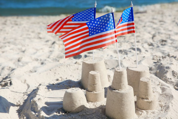 Naklejka premium Sand castle with American flags on beach
