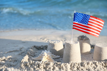 Sand castle with American flag on beach