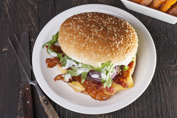 juicy  bacon cheese bbq burger on wooden table with fries