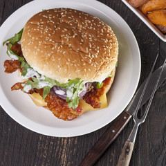 juicy  bacon cheese bbq burger on wooden table with fries