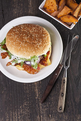 juicy  bacon cheese bbq burger on wooden table with fries