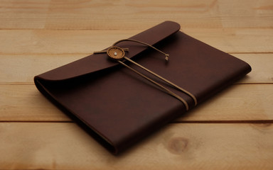 close up brown diary on wood desk in warm tone