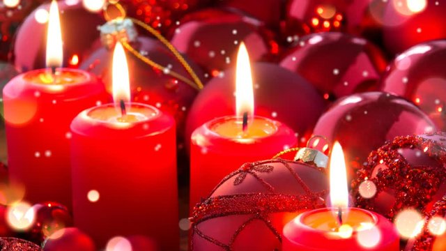 Adventskranz mit 4 roten Kerzen und goldenem Bokeh und Schneefall