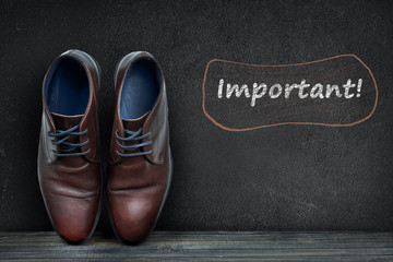 Important text on black board and business shoes