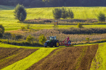 Traktor rolniczy podczas prac polowych na polu - obrazy, fototapety, plakaty