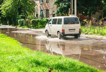 minibus riding on big puddle on the road