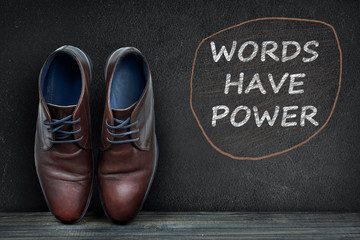 Words have power text on black board and business shoes