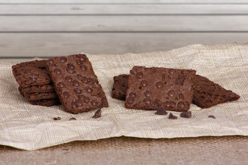 Knusprige Kekse auf einer Serviette vor einer Holzwand