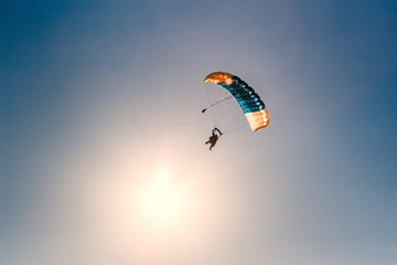 Silhouette of parachute on sunset background