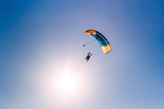 Silhouette of parachute on sunset background