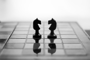 Chess is an strategy and intelligence board game originated in India that is played between two people on a chessboard. Knights face to face. - 119433608