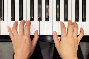 Close up of young girls hands, playing piano. vintage tone filte
