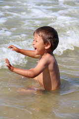 Petit garçon jouant dans la mer 