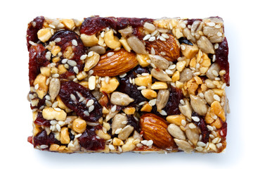 Fruit, nut and seed bar with cranberries isolated on white.