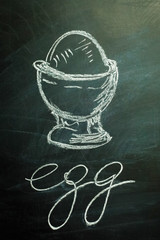 Boiled egg drawn on a black dirty chalkboard