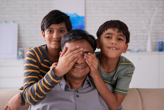 Kids Covering Eyes Of Their Father From Behind