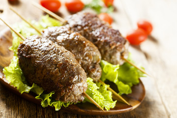 Kebab skewers with green salad and tomatoes