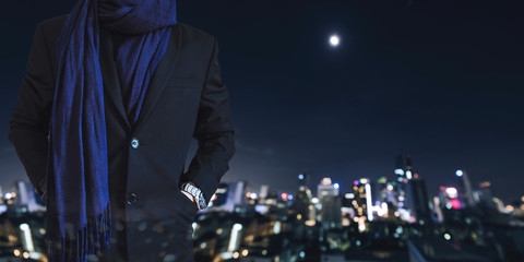 Businessman hand in pcoket with defocused city at night background