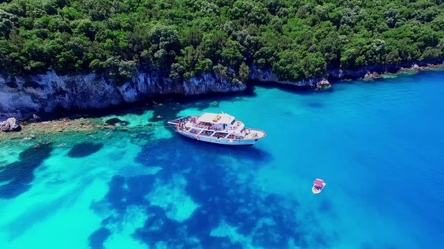 Tropical Ionian Greece island aerial 4k travel video. Yacht boat on blue water in ocean sea, forest coast seashore
